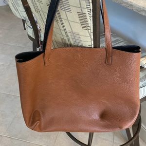 Reversible black and cognac brown magnetic closure tote bag.